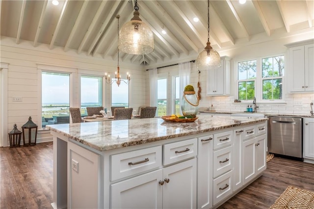 kitchen featuring white cabinetry, dark wood finished floors, decorative backsplash, stainless steel dishwasher, and a center island