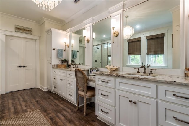 bathroom with a shower stall, vanity, crown molding, and wood finished floors