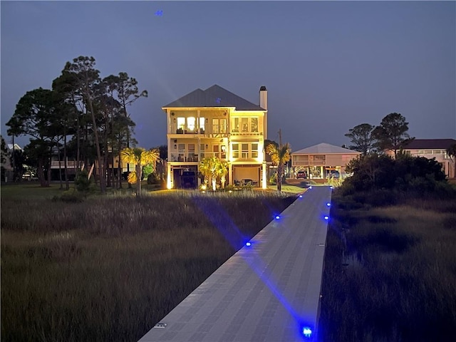 back of property featuring a garage and a balcony