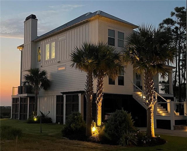 property exterior at dusk with a garage and stairs