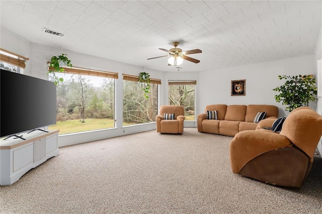 carpeted living area featuring ceiling fan and visible vents