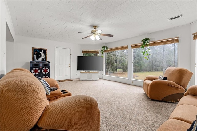 living area with ceiling fan, carpet flooring, and visible vents