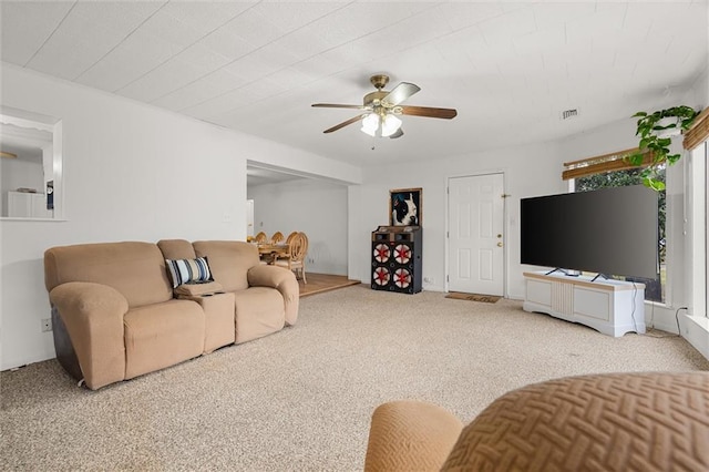 living area with light carpet, ceiling fan, and visible vents