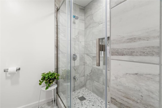 bathroom with a shower stall and baseboards