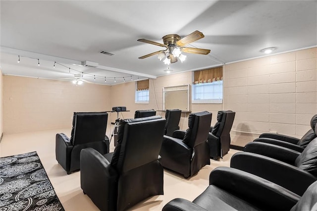 cinema room with a ceiling fan, concrete block wall, and visible vents