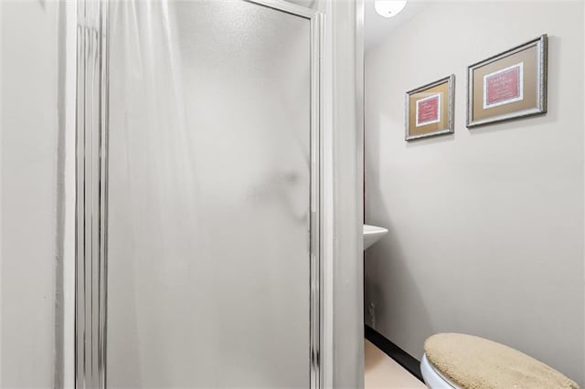 full bath featuring toilet and a shower stall