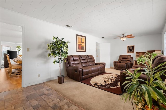 living area featuring visible vents, baseboards, ceiling fan, stone finish flooring, and carpet flooring