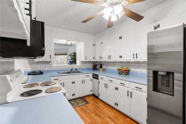 kitchen with stainless steel appliances, white cabinets, light countertops, and a sink