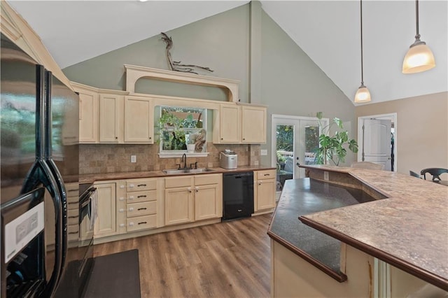 kitchen featuring french doors, decorative light fixtures, a sink, high vaulted ceiling, and black appliances