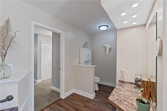 bathroom featuring toilet, baseboards, and wood finished floors