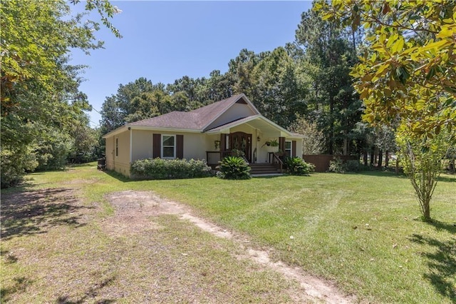 ranch-style house featuring covered porch, stucco siding, and a front lawn