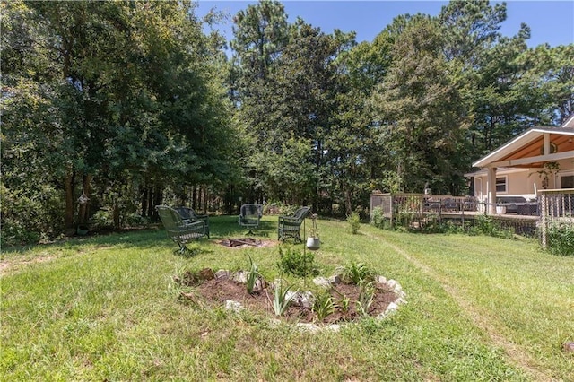 view of yard with a deck and an outdoor fire pit