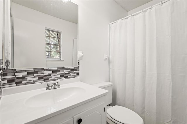 bathroom with tasteful backsplash, vanity, and toilet