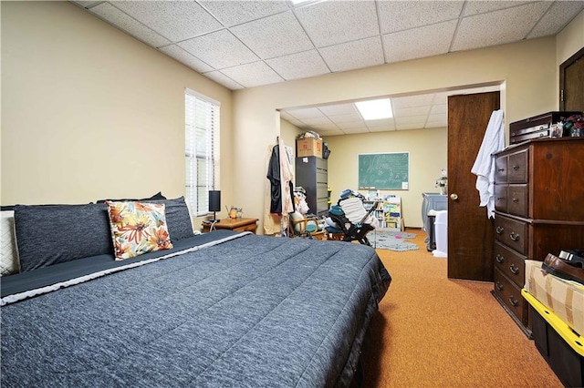 bedroom with a drop ceiling and carpet floors