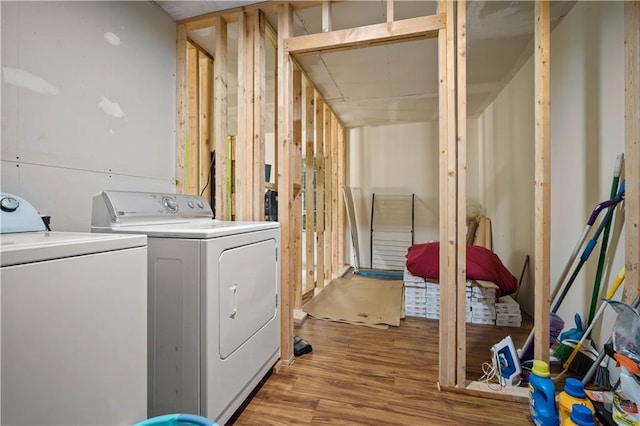 clothes washing area with washer and clothes dryer and light hardwood / wood-style floors