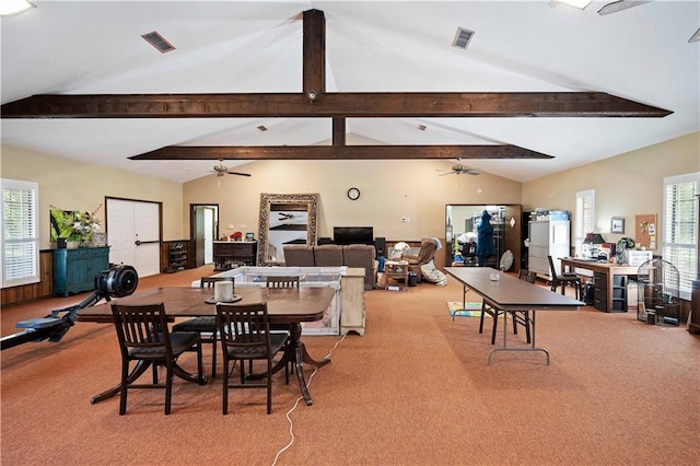 carpeted dining space featuring vaulted ceiling with beams, ceiling fan, and plenty of natural light