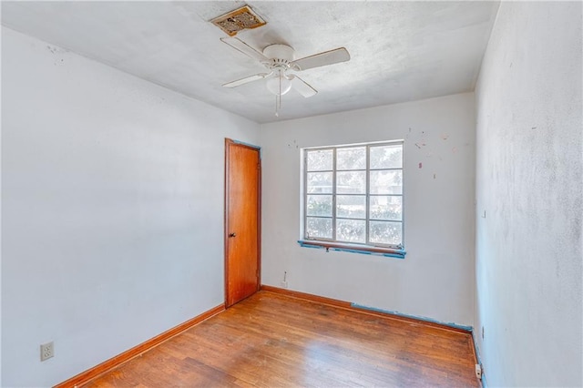 unfurnished room featuring a ceiling fan, baseboards, and wood finished floors