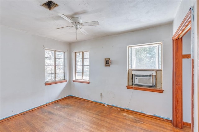 unfurnished room featuring ceiling fan, cooling unit, and wood finished floors