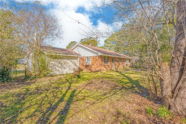 view of property exterior featuring brick siding and a lawn