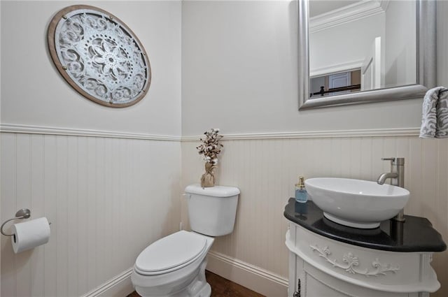 bathroom featuring wainscoting, vanity, and toilet