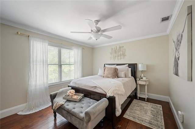 bedroom with baseboards, crown molding, visible vents, and wood finished floors