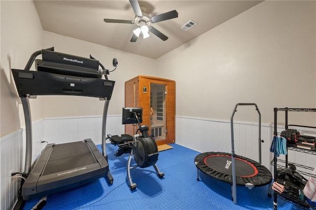 workout area featuring carpet floors, ceiling fan, visible vents, and wainscoting