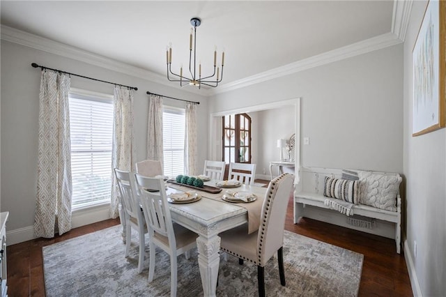 dining area featuring ornamental molding, wood finished floors, baseboards, and an inviting chandelier