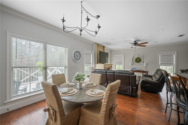 dining space featuring ceiling fan with notable chandelier, dark wood-style flooring, visible vents, and crown molding