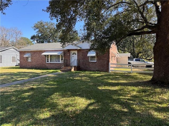 view of front facade with brick siding, crawl space, a front yard, and fence