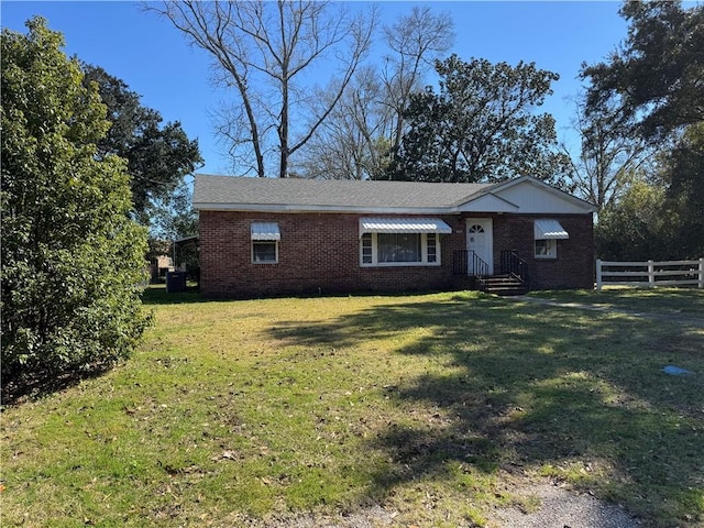 view of front of property featuring fence, a front lawn, and brick siding