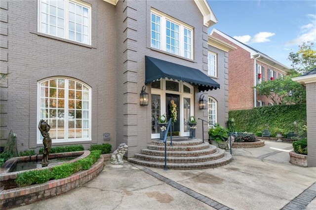 doorway to property with brick siding