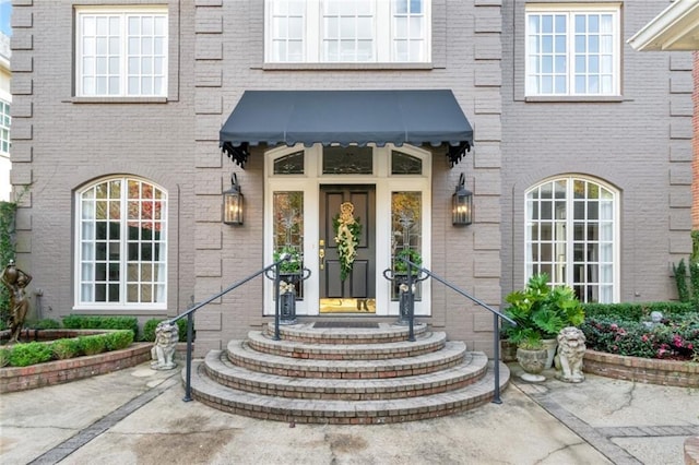 property entrance featuring brick siding