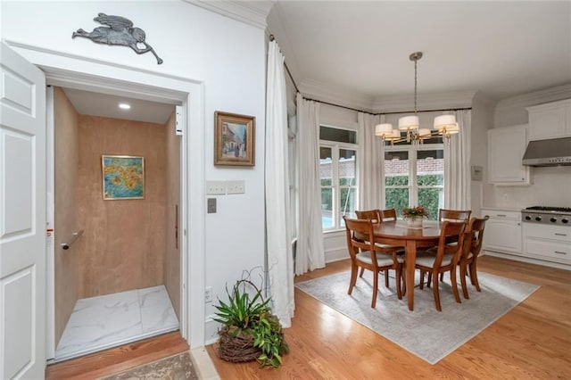 dining room with a notable chandelier, ornamental molding, and light wood-style floors