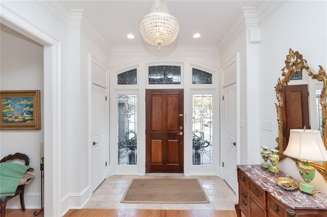 entrance foyer featuring light hardwood / wood-style floors, ornamental molding, and an inviting chandelier