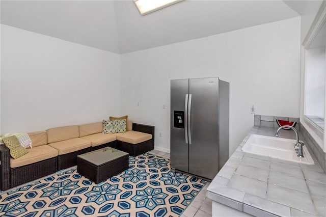 tiled living room with sink and vaulted ceiling