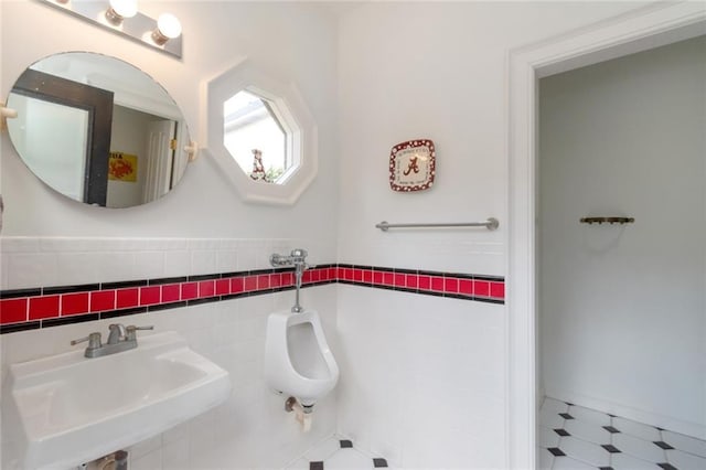 bathroom with a sink, tile walls, and tile patterned floors