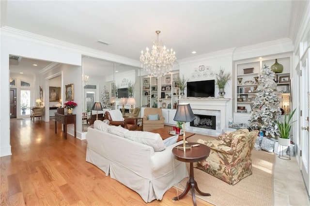 living room with french doors, an inviting chandelier, built in features, light hardwood / wood-style floors, and ornamental molding