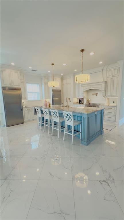 kitchen featuring stainless steel built in refrigerator, pendant lighting, a breakfast bar, recessed lighting, and marble finish floor