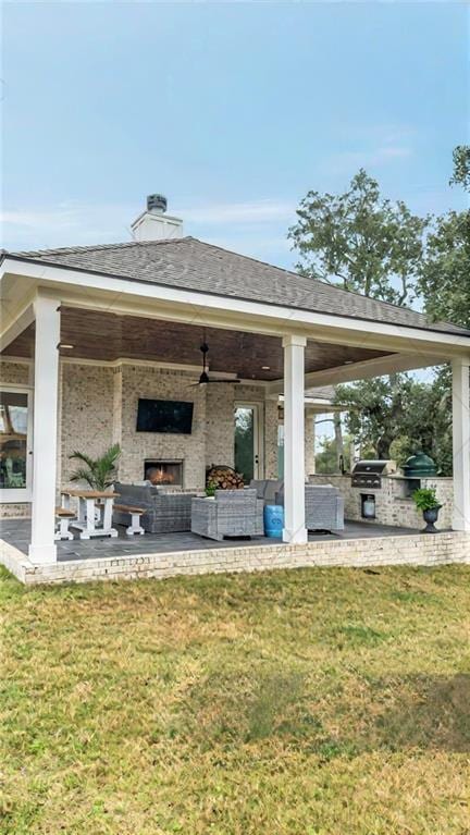 view of patio featuring area for grilling and an outdoor living space with a fireplace