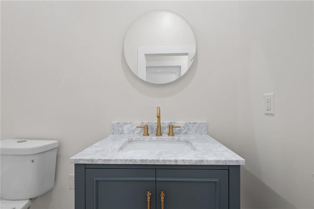 half bathroom with toilet and vanity