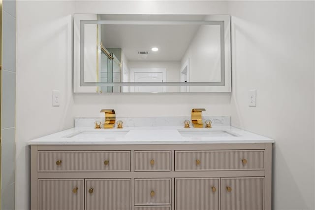 bathroom with visible vents, a sink, and double vanity