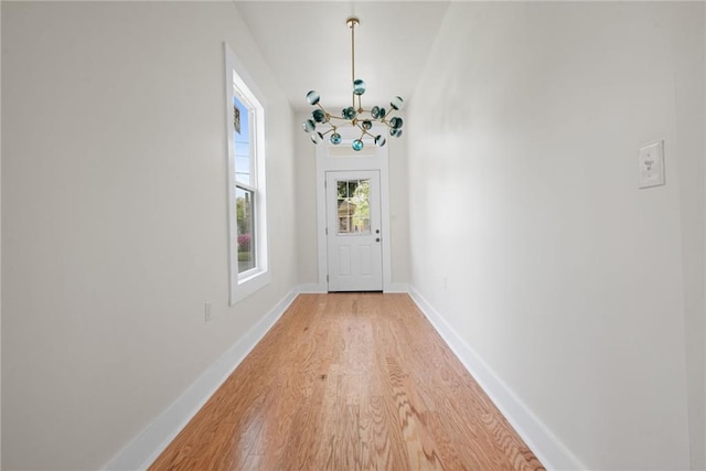doorway with baseboards and light wood-type flooring