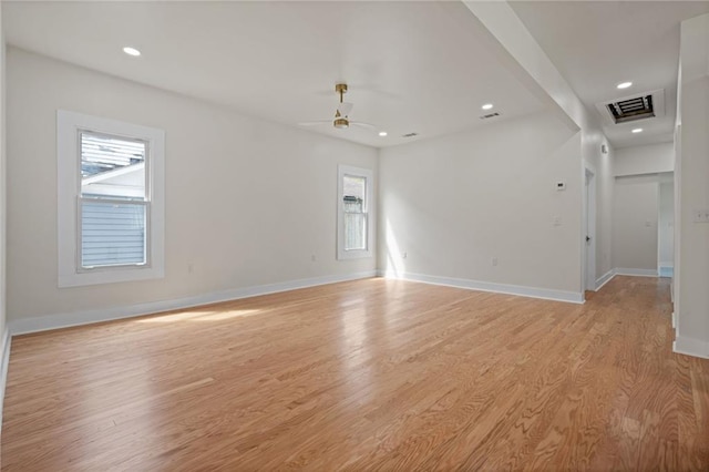 unfurnished room featuring baseboards, visible vents, light wood-style floors, and a ceiling fan