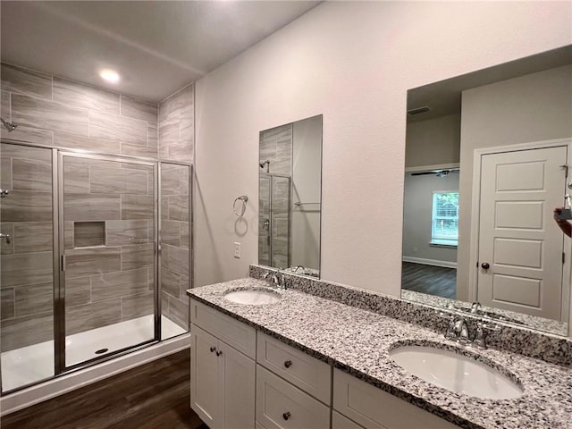 bathroom featuring hardwood / wood-style floors, vanity, and walk in shower