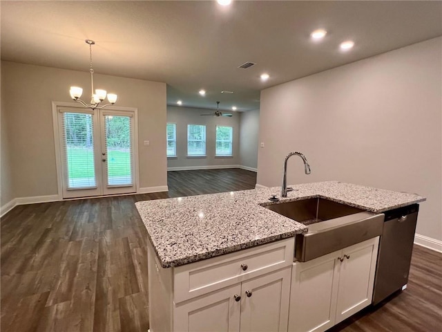 kitchen with white cabinets, ceiling fan with notable chandelier, sink, stainless steel dishwasher, and decorative light fixtures