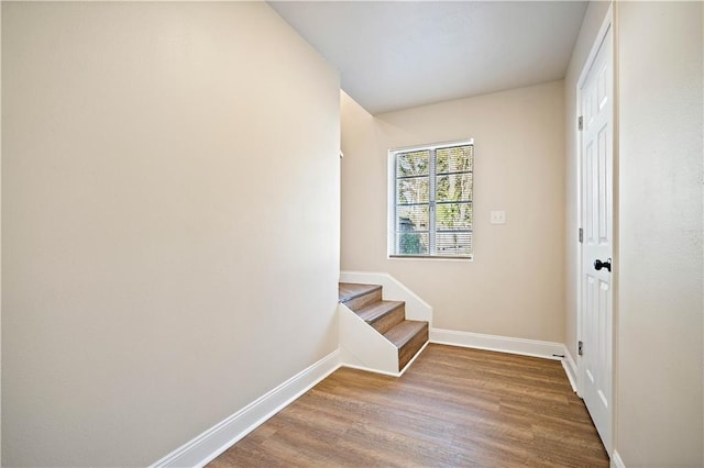 interior space with stairs, baseboards, and wood finished floors