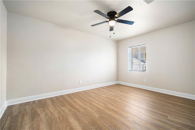 empty room with ceiling fan, baseboards, and wood finished floors