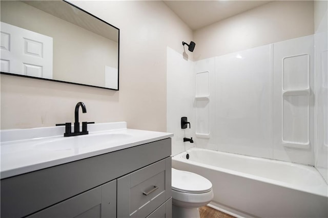 bathroom featuring vanity, toilet, and shower / washtub combination