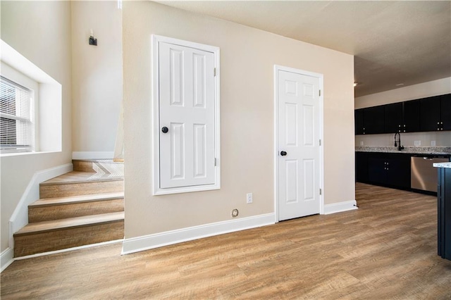 interior space with a sink, baseboards, and light wood-style flooring