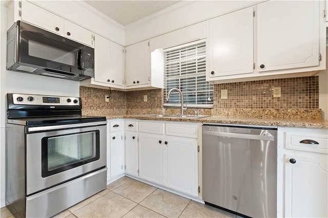 kitchen featuring sink, light tile patterned floors, appliances with stainless steel finishes, white cabinetry, and tasteful backsplash